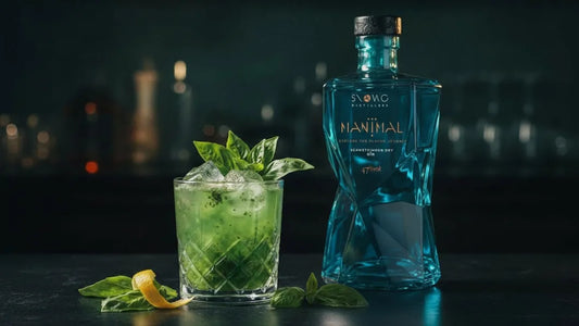 Gin Basil Smash Cocktail mit Eis, Basilikum und Zitrone neben stilvoller Gin Flasche