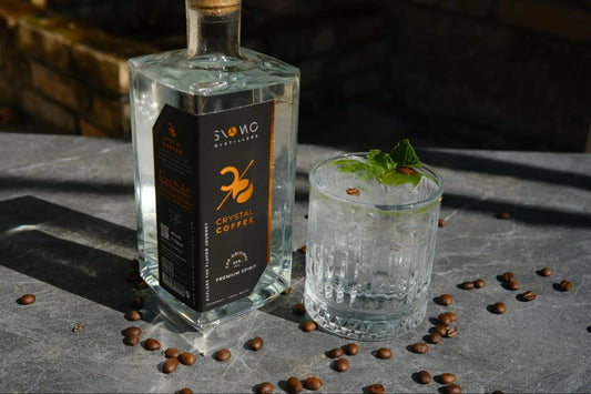Erfrischendes Ostergetränk aus Kaffee mit Gin, Tonic Water, Eis und Minze neben einer Crystal Coffee Flasche