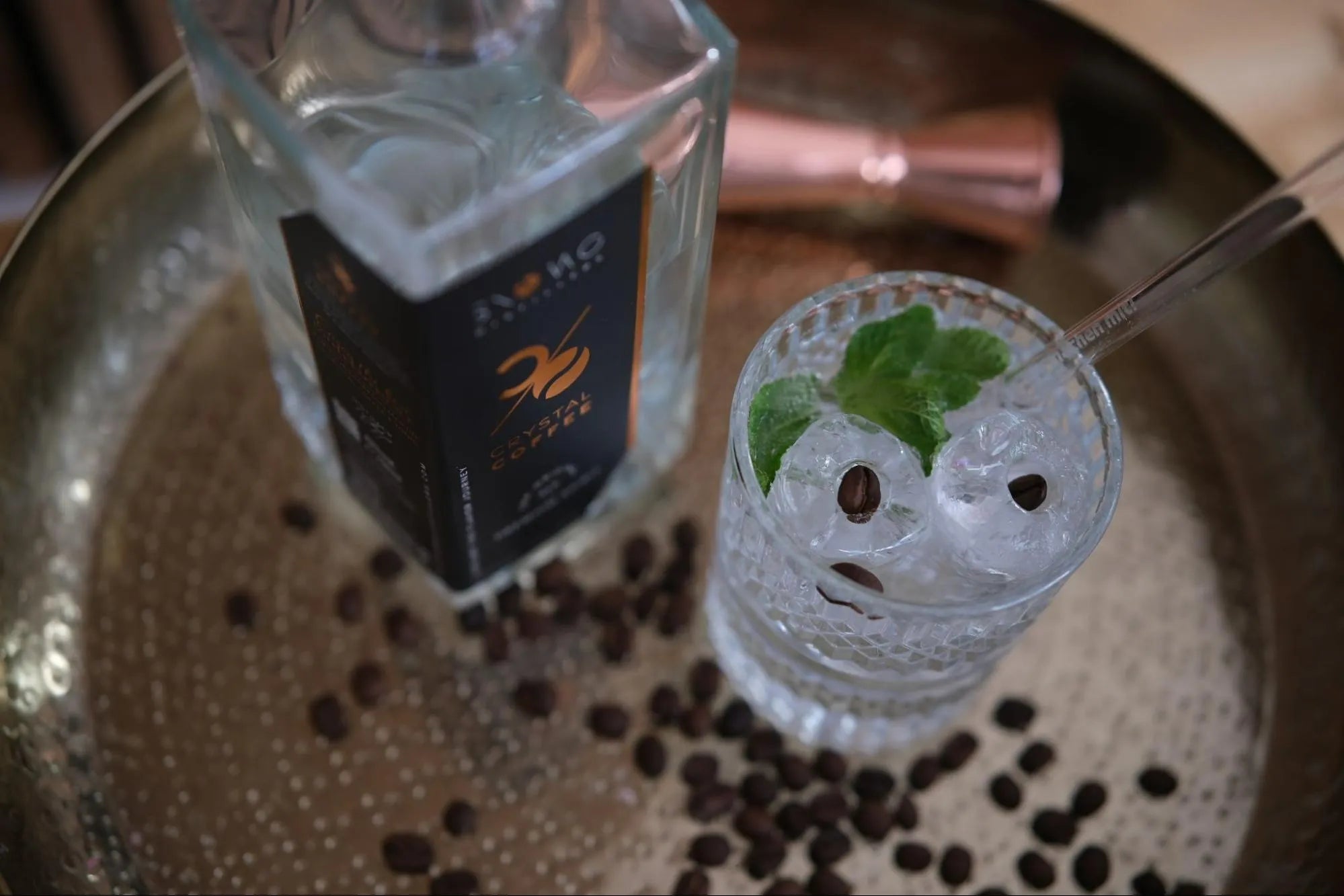 Crystal Coffee & Tonic Cocktail als Ostergetränk mit Eiswürfeln, Minze und Kaffeebohnen in einem Glas von oben fotografiert